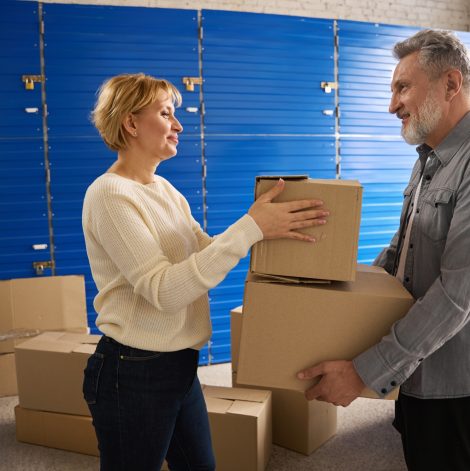 Lady and male with cardboard boxes in self storage unit Lady and male with cardboard boxes in self storage unit